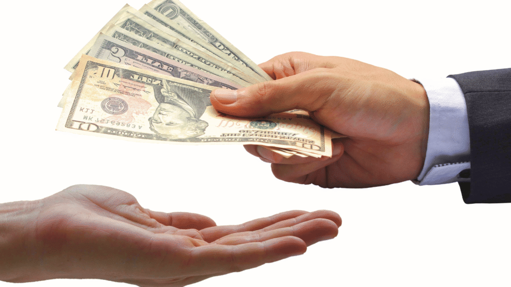 يد تسلم نقوداً ليد أخرى، ترمز إلى راتب ودخل مرتفع من وظائف بدون شهادة جامعية في السعودية.