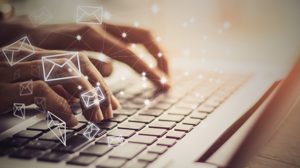صابع تكتب على لوحة مفاتيح بينما تطفو أيقونات البريد الإلكتروني، في تعبير عن التسويق عبر البريد الإلكتروني والإنتاجية الرقمية. وكتابة رسالة قبول عرض وظيفي.