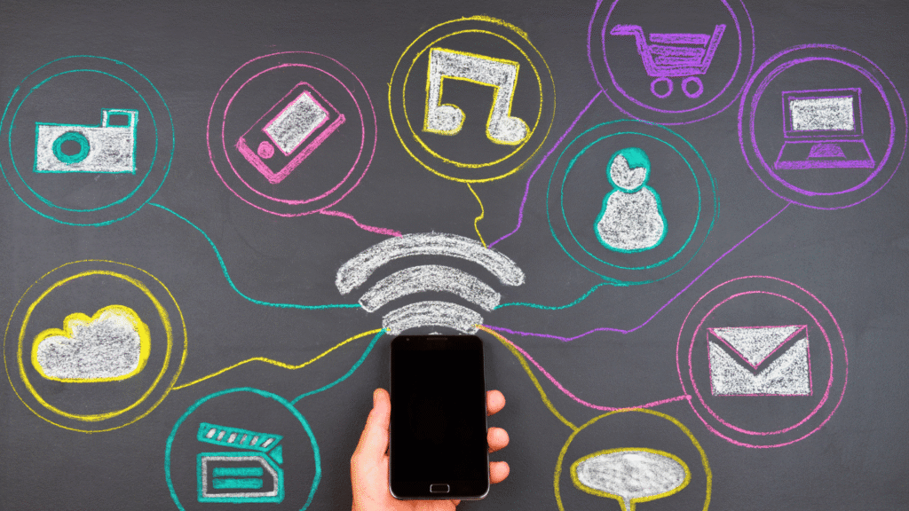 هاتف ذكي محاط برسومات بالطباشير تمثل شبكة الاتصال والتواصل الاجتماعي والمحتوى المرئي والمسموع (الإعلام والتقنية).