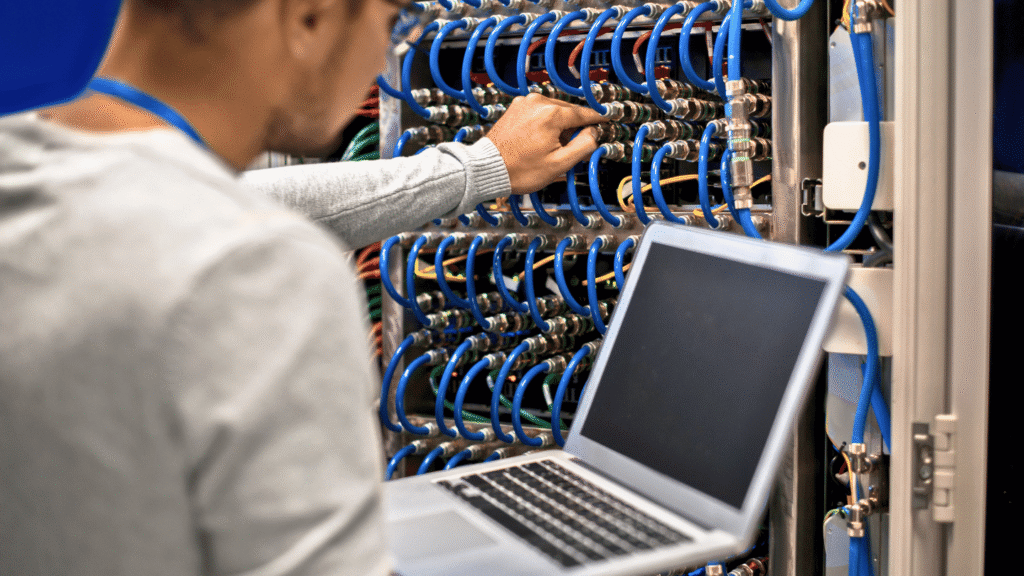 فني شبكات يستخدم حاسوب محمول لفحص كابلات الخادم ولوحة التوزيع، وهي وظيفة بدون شهادة لكنها تتطلب دورات تخصصية (مثل CCNA).
