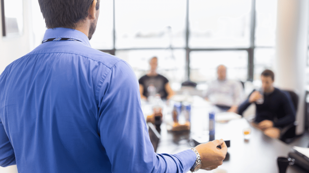 متحدث يقدم عرضاً لزملائه في اجتماع. يمثل تطوير المهارات القيادية ومهارات العرض كجزء من التطوير المهني المطلوب للترقية والمهارات الادارية والعرض التقديمي.