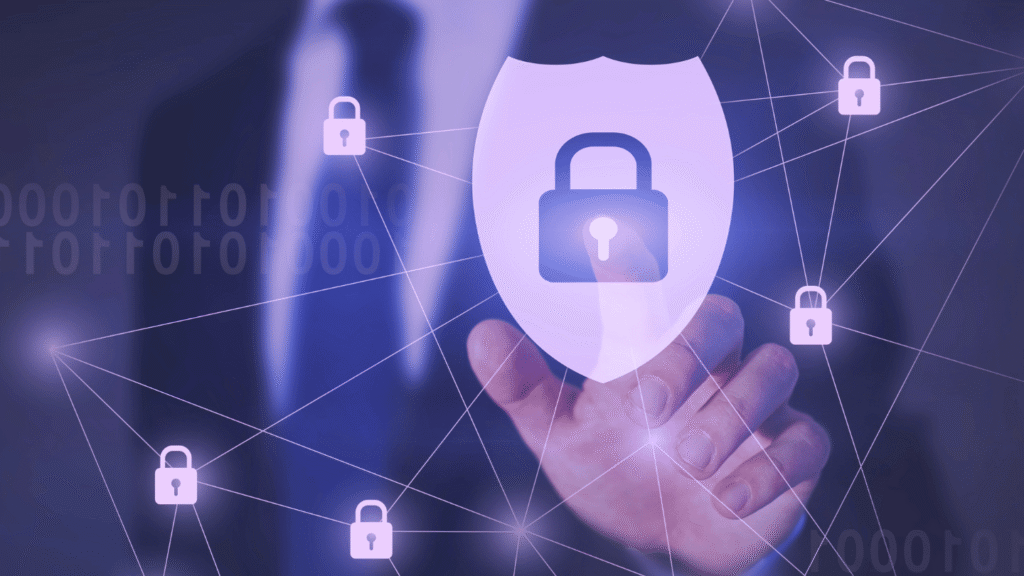 يد رجل ببدلة رسمية سوداء تلامس بشكل افتراضي قفل أزرق كبير مضيء داخل درع أبيض، محاط بأقفال صغيرة متصلة بخطوط رقمية، مع أرقام ثنائية في الخلفية الداكنة – يرمز إلى الحماية الرقمية في عالم الأمن السبراني.